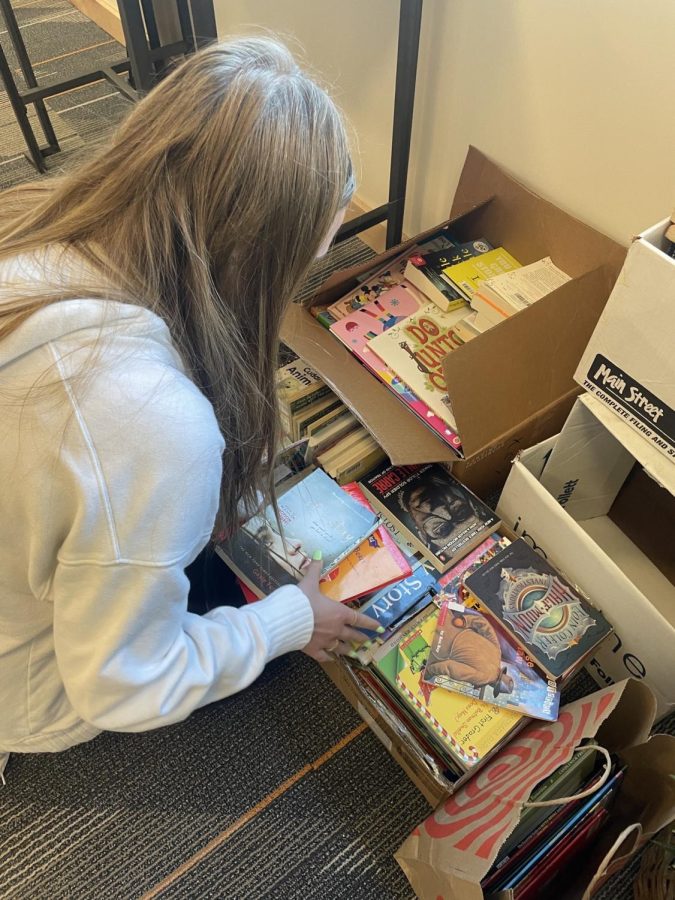 Savannah+York+%2810%29+sorts+through+books+donated+during+the+book+drive.+The+book+drive+was+held+from+March+6+to+March+24+by+Interact+Club+students.+%28Madi+Romme%29