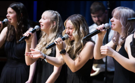 Jillian Creamer (12), Joy Perry-Grice (11), Emma Siebert (22) and Opal Schlessman (11) sing at the UNC Jazz Fest in May 2022. Choir students are trying to increase participation in the choir program for the next school year. (Photo courtesy of Woody Myers)