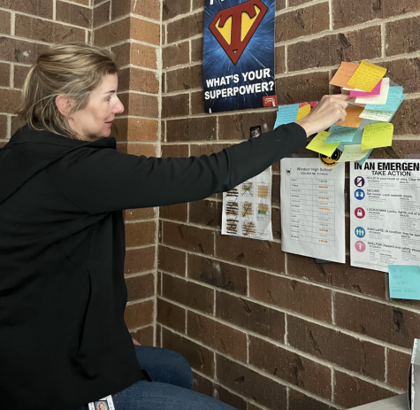Laure Hiebenthal (staff) talks while pointing to a current Make-a-Day-Monday project. Her classes worked on making a poster for superintendent Michelle Scallon’s birthday. (Mykalah Lulich)