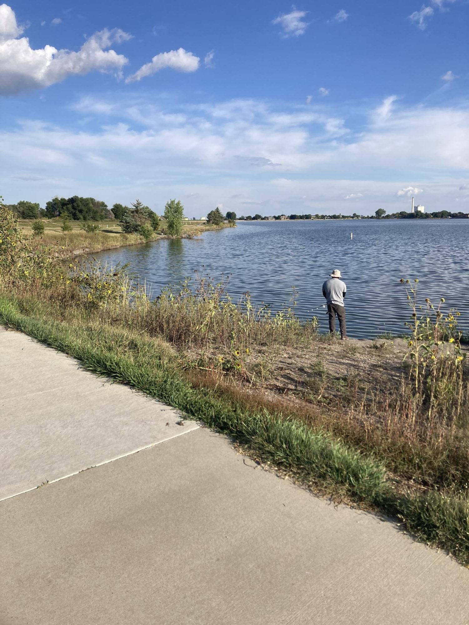 A man fishes at Windsor Lake on Sept. 16 along the west bridge. Now that the algae is gone, more people seem to be fishing and using the lake for activities.