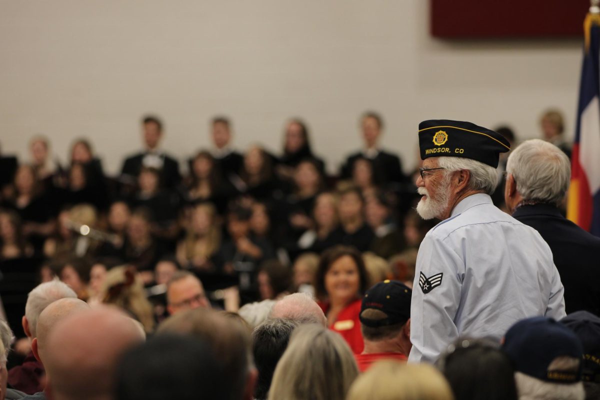 U.S. veteran Jim Porth stands to watch the performers sing the Armed Forces Medley. Porth served in the Air Force from 1966 to 1970 and attends the Veterans Day assembly every year.