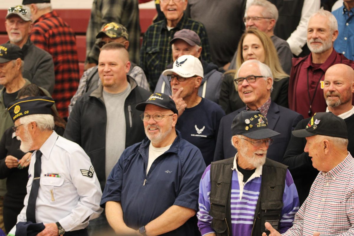 Veterans from various military branches pose for a group photo after the assembly. Veterans Day is a way to honor those who have served in the military. 