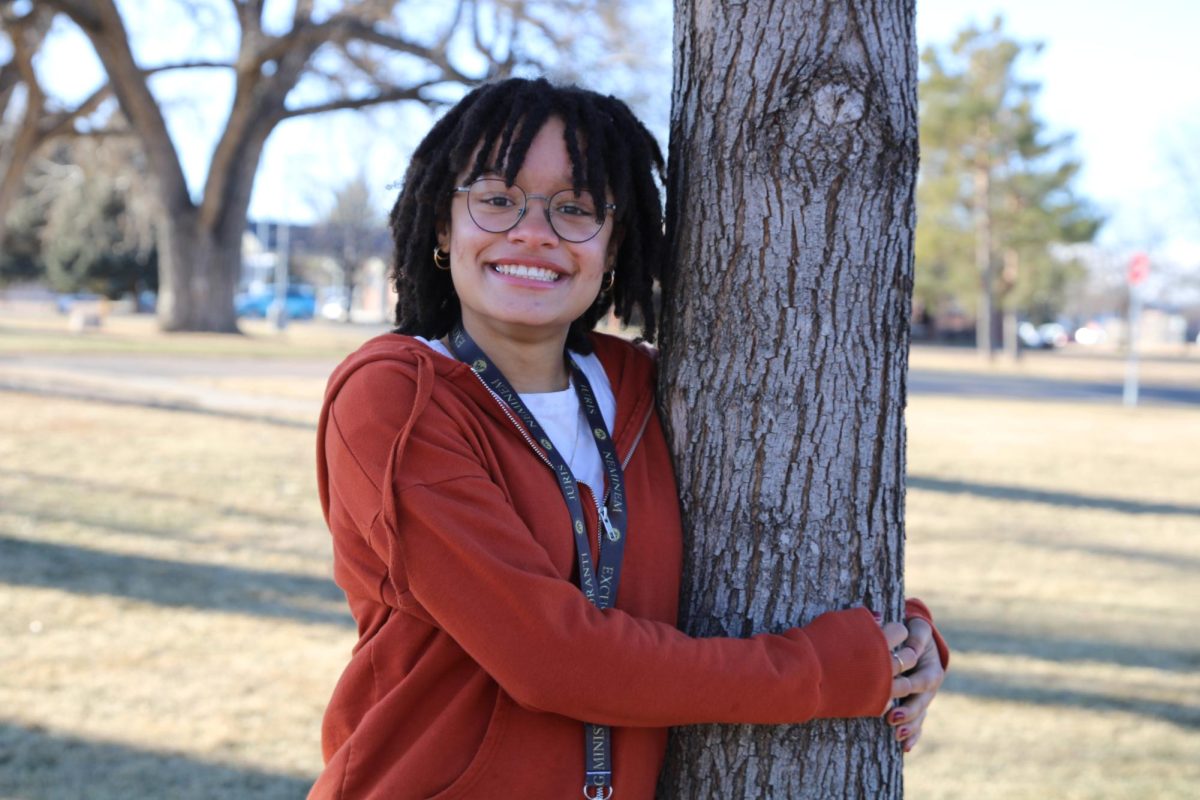 Reporter Maya Brasch (10) stands against a tree and smiles.