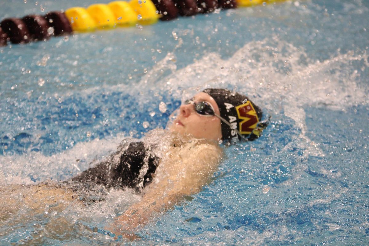 Ainsley Austin (10) swims backstroke at the Ugly Sweater Invite on Dec. 22. Austin qualified for state in two events: the 100 backstroke and the 200 relay. 