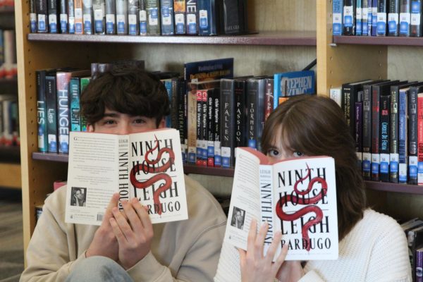 Oliver Lodato (10) and Sophia Jensen (11) pose for a photo with Ninth House by Leigh Bardugo. Their first episode of the Soap and Ollie show explores the authors world of secret societies.