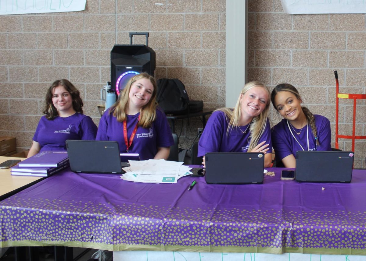 Raven Bowman (12), Lauren Huntsman (12), Hanna McKay (11) and Mykalah Lulich (11) sit at the yearbook distribution booth on Wednesday, May 15, during the signing party. The staff spent all year creating the book and sold more than 785 books. (Kerri Cassity)