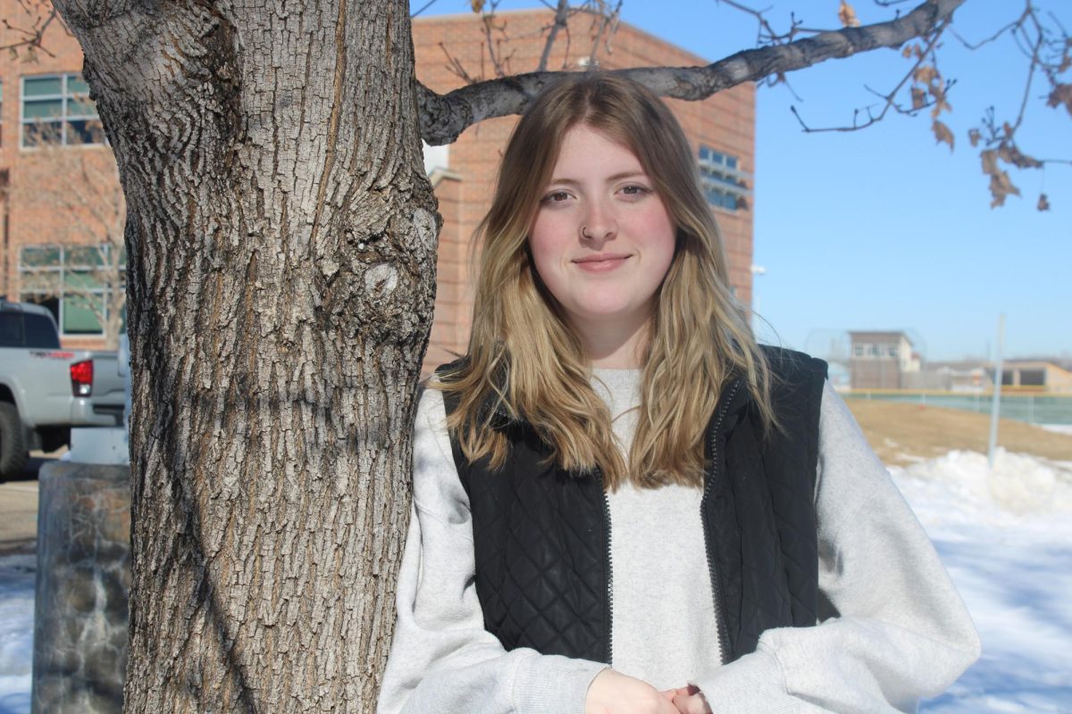 Alyssa Smith (12) stands against a tree and smiles