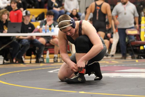 Studet laces shoes in preparation for a wrestling match