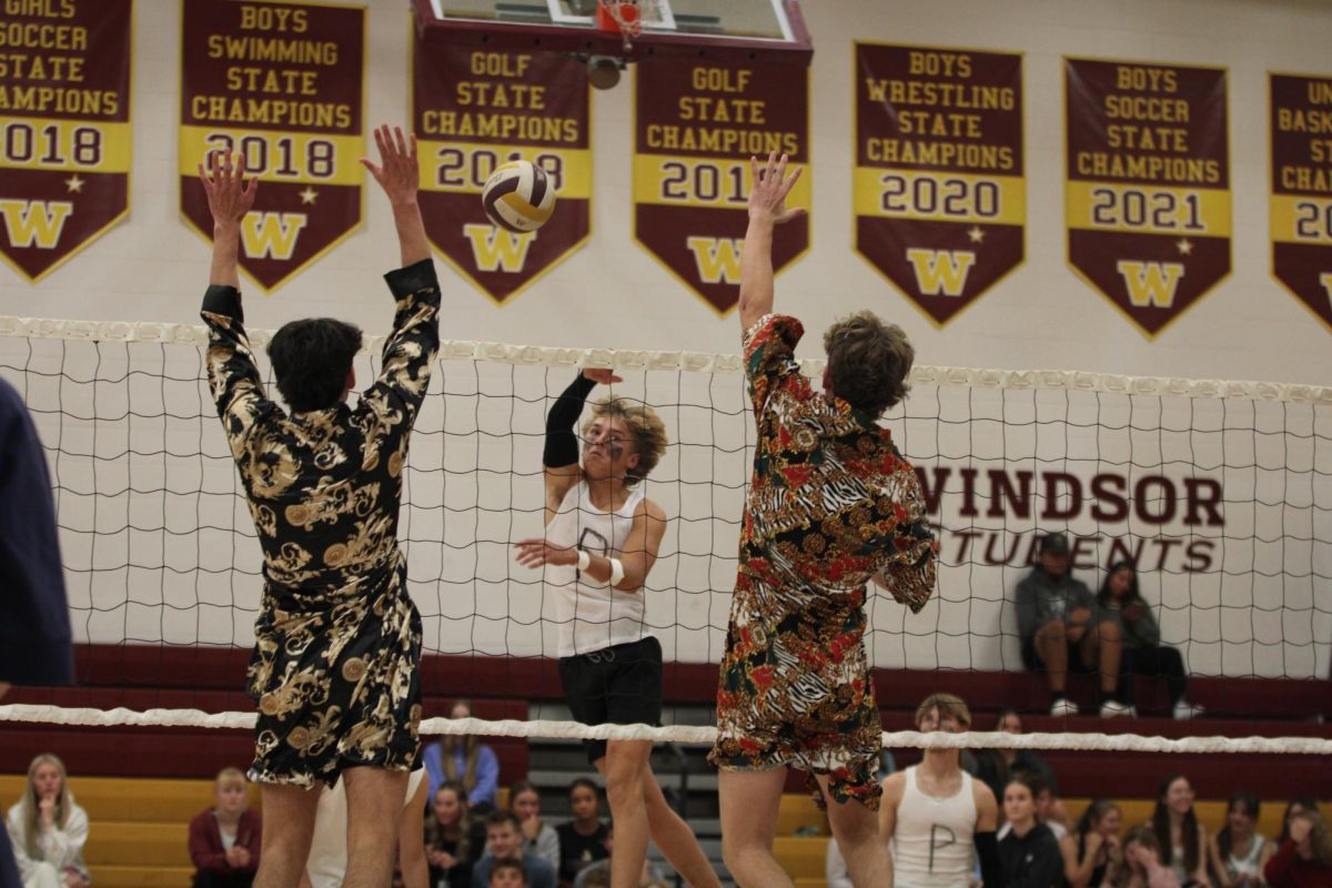 Students jump to hit the volleyball over the net during peach fuzz