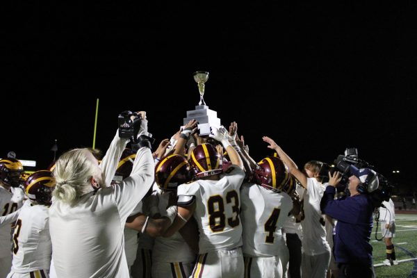 Group of football players lift a trophy