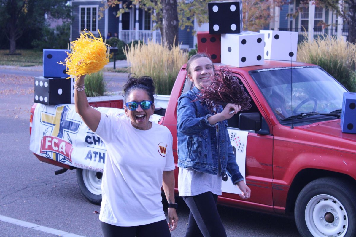 Fellowship of Christian Athletes walks alongside their float. FCA won second place in the homecoming parade on Thursday, Oct. 17.