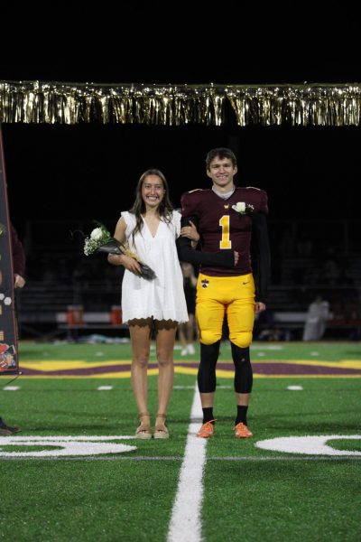 Two seniors nominated to homecoming royalty walk down the football field together 