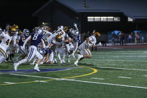 Football player runs out of a group of other football players