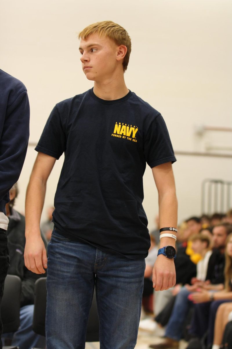 Michael Webb (12) stands to be recognized at the Veterans Day assembly. Webb was one of nine students entering the military after graduation. 