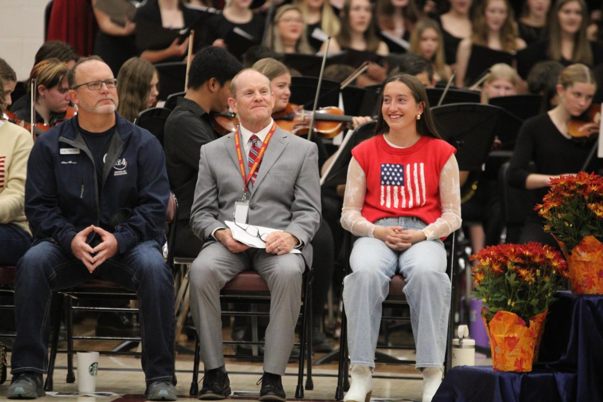 Principal Dick Thomas (staff) accompanies Leah Bacon (12) in recognizing important people in the Windsor community. “The significance of this assembly, for me anyway, and I’m hoping for the students and staff, is to pay respects to the veterans that sacrificed maybe years of their lives to the military to protect our freedom and our country.”