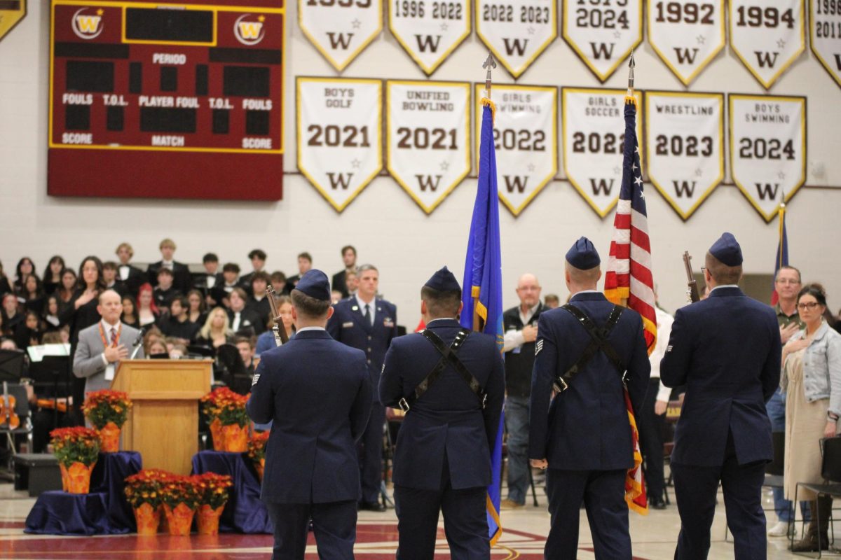 Students, staff and veterans of Windsor High School rise as the National Color Guard presents the colors. The Color Guard has been seen at numerous football games throughout the season, including the football game on Nov. 16, which included the presentation of colors as well as a local flyover. 