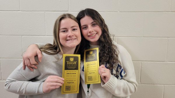 Two students pose with golden tickets