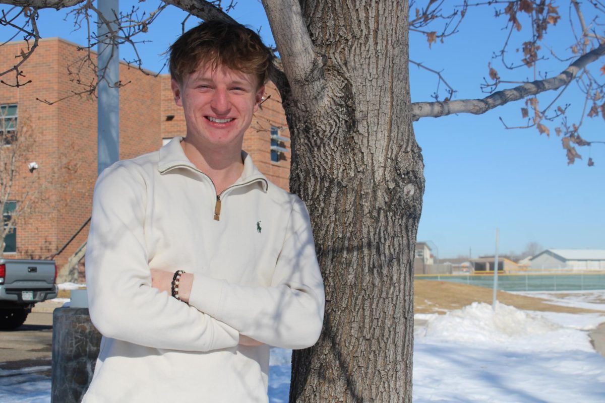 Torin Schleiger (12) stands against a tree and smiles