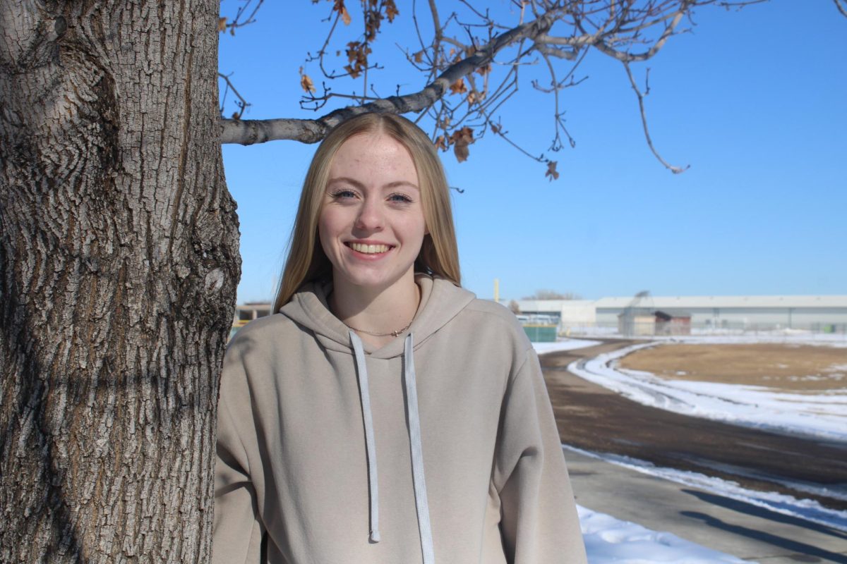 Karis Beeman (10) stands against a tree and smiles