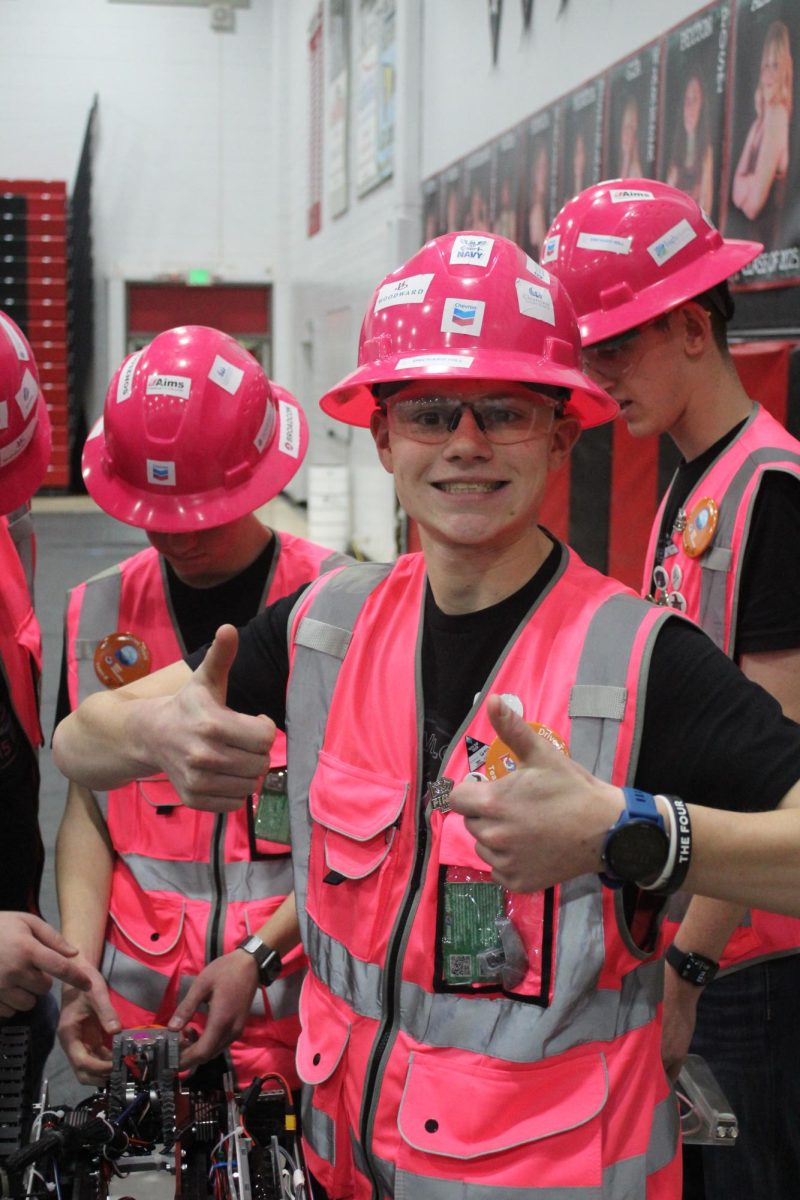 Michael Webb (12) smiles before a robotics match on Feb. 1 at Loveland High School. "I enjoy the collaboration and just the fun times that we have in the lab," Webb said. "Building our robot and just competing ... is fun."