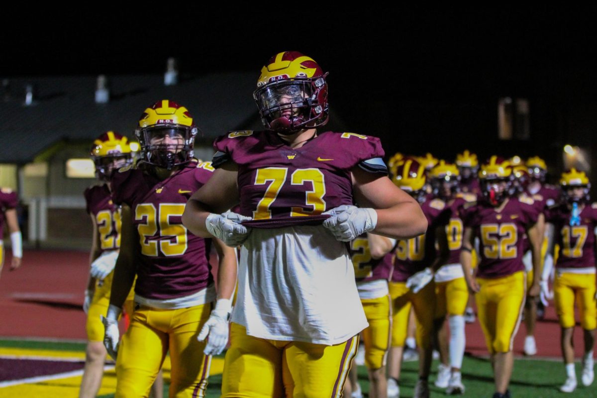 Deacon Schmitt (11) walks alongside his team to face Montbello High School in their second game of the season on Friday, Sept. 13. Schmitt has received more than 20 offers to play football in college.