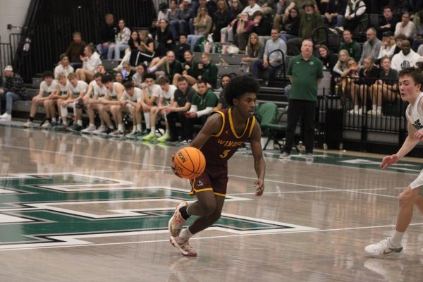 basketball player runs up the court with the ball in hand