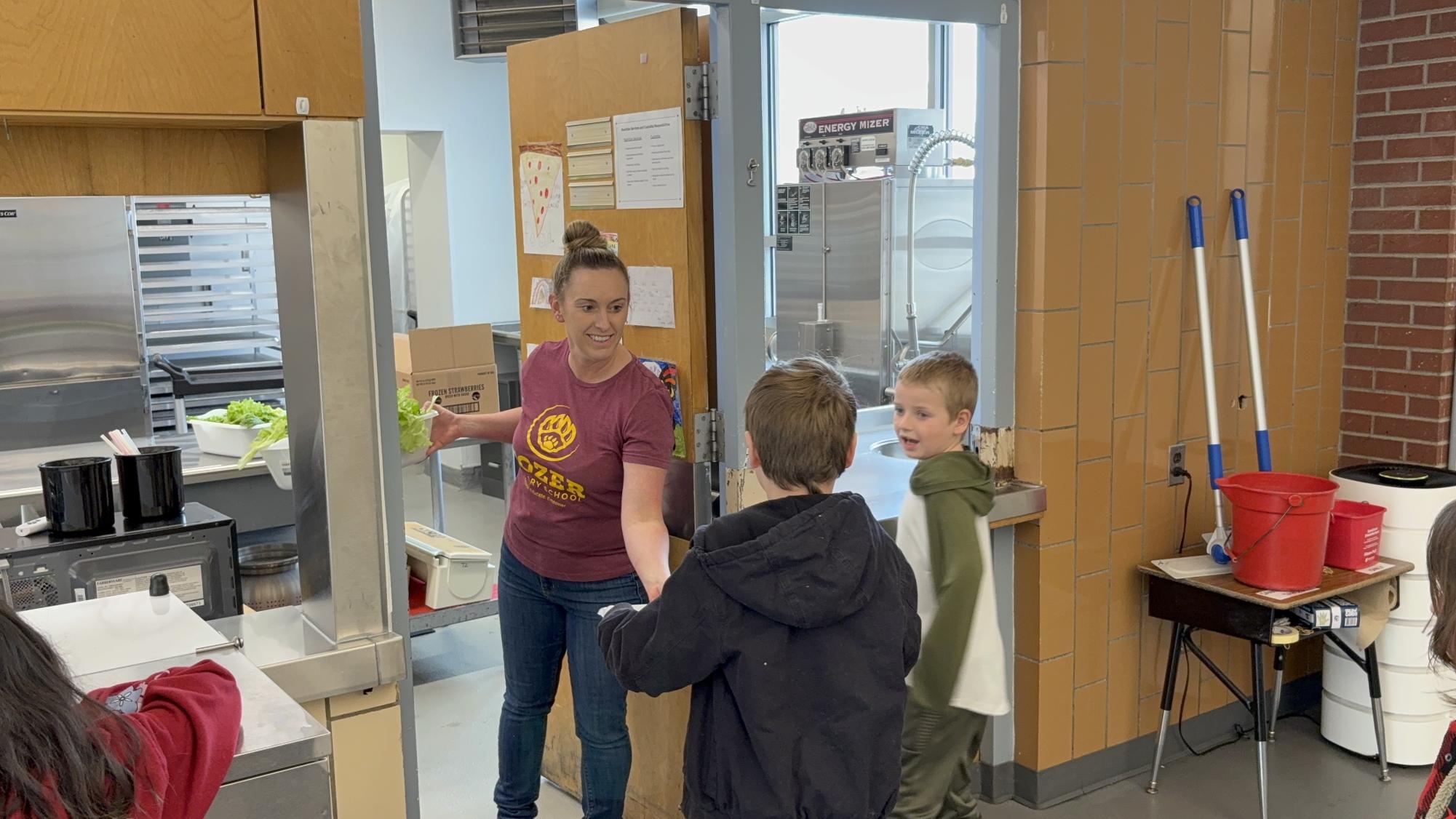 Second grade students at Tozer give fresh vegetables to cafeteria staff to serve at lunch. The students grew this food using a tower garden and the help of Windsor FFA students.