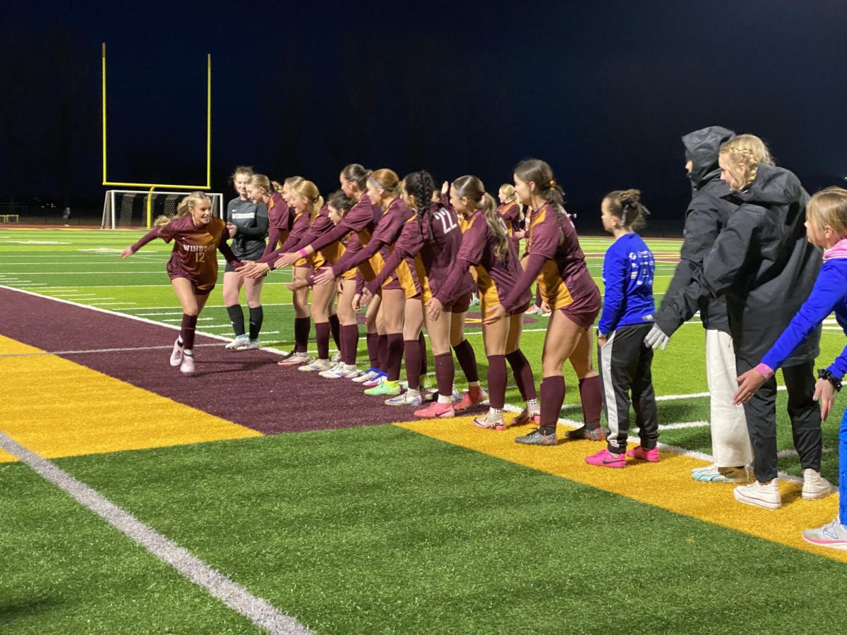 Ambry Plate (11) runs down the line and high fives her teammates at the start of their first game. Plate was a major influence in the midfield. 