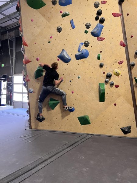 Student climbs a rock wall