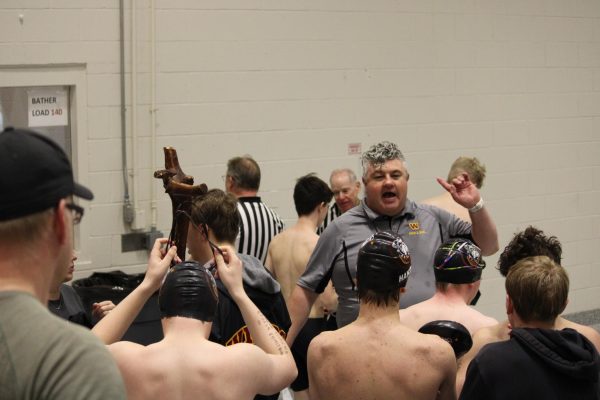 Coach talks to students in the swimming pool room