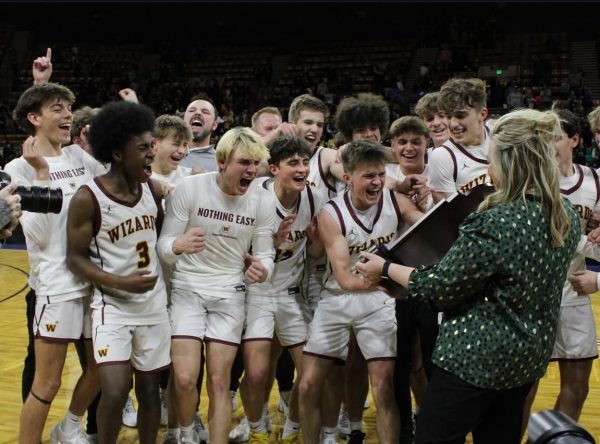 The boys basketball team accepts the trophy after winning the state title on March 16. The team beat Green Mountain in the final, bringing the trophy back to WHS after 101 years. 