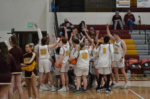 The Unified Basketball team cheers before their City Showcase game on March 20. Some students attended the game to get footage for the Reel Impact Showcase.