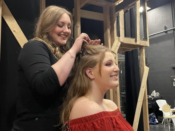 girl braids another girl's hair