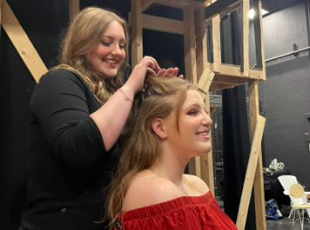 Sariah Richmond (11) braids Emily Irwin’s (11) hair before a rehearsal. “I start the show in this, like, fishtail braid because we‘re in Greece, so it’s supposed to be all Summer-y,” Irwin said. “And then during the wedding, I take it out because it’s supposed to be, like, a nice occasion.”