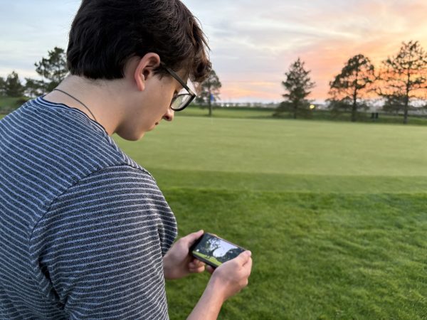 Luke Harris (12) watches the masters at Boomerang Links golf course in Greeley. The playoff hole had everyone holding their breath.