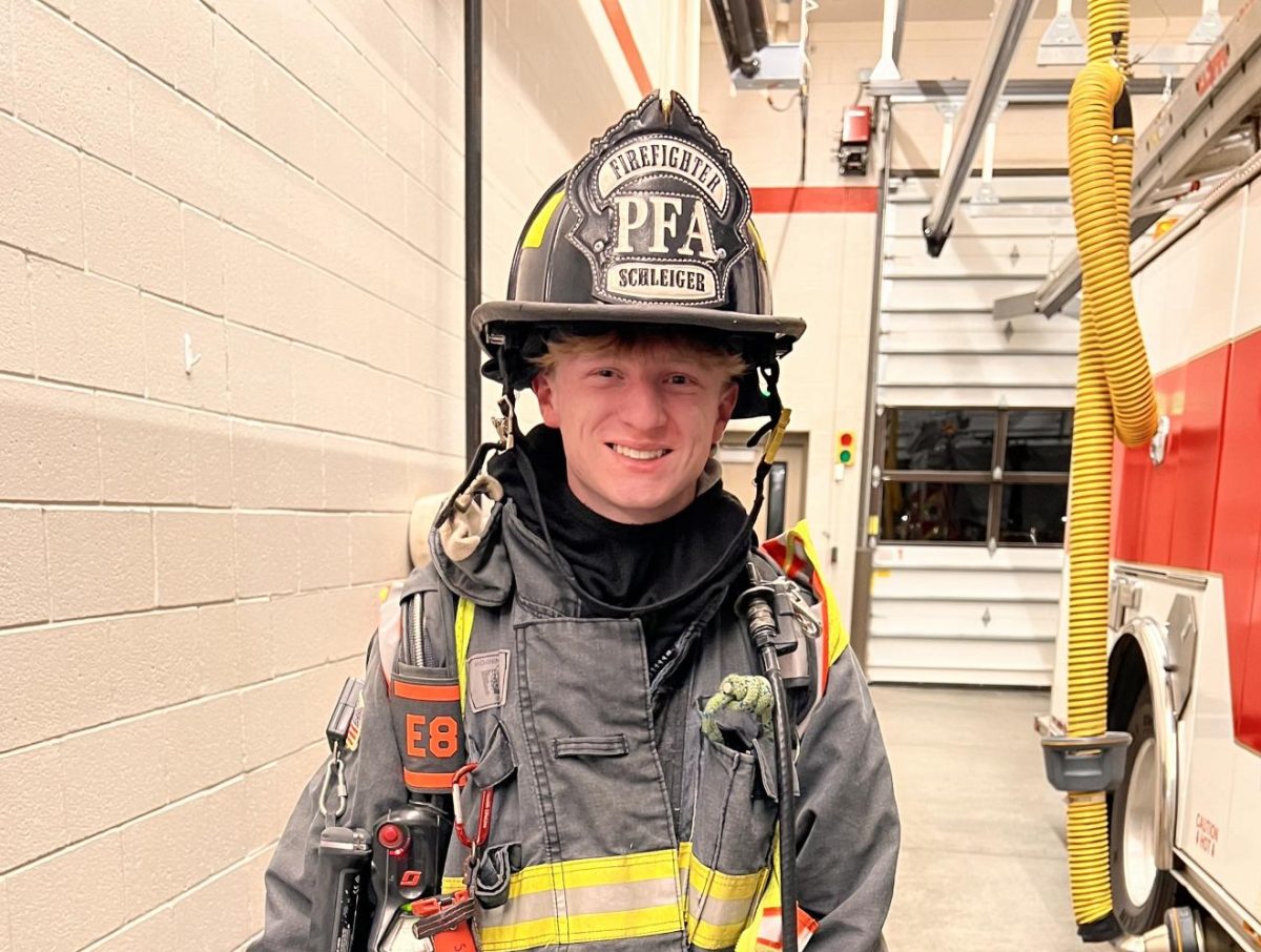 Schleiger sports his dad's bunker gear on a visit to the firehouse. Schleiger's dad graduated from Windsor High School in 2004. (Photo provided by Torin Schleiger)