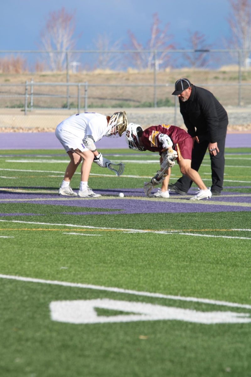 Logan Stevens (11) faces off against an opponent from Thompson Valley as they both prepare to get the ball first and start the game. "It is really nerve racking starting a game but at the same time really fun," Stevens said.